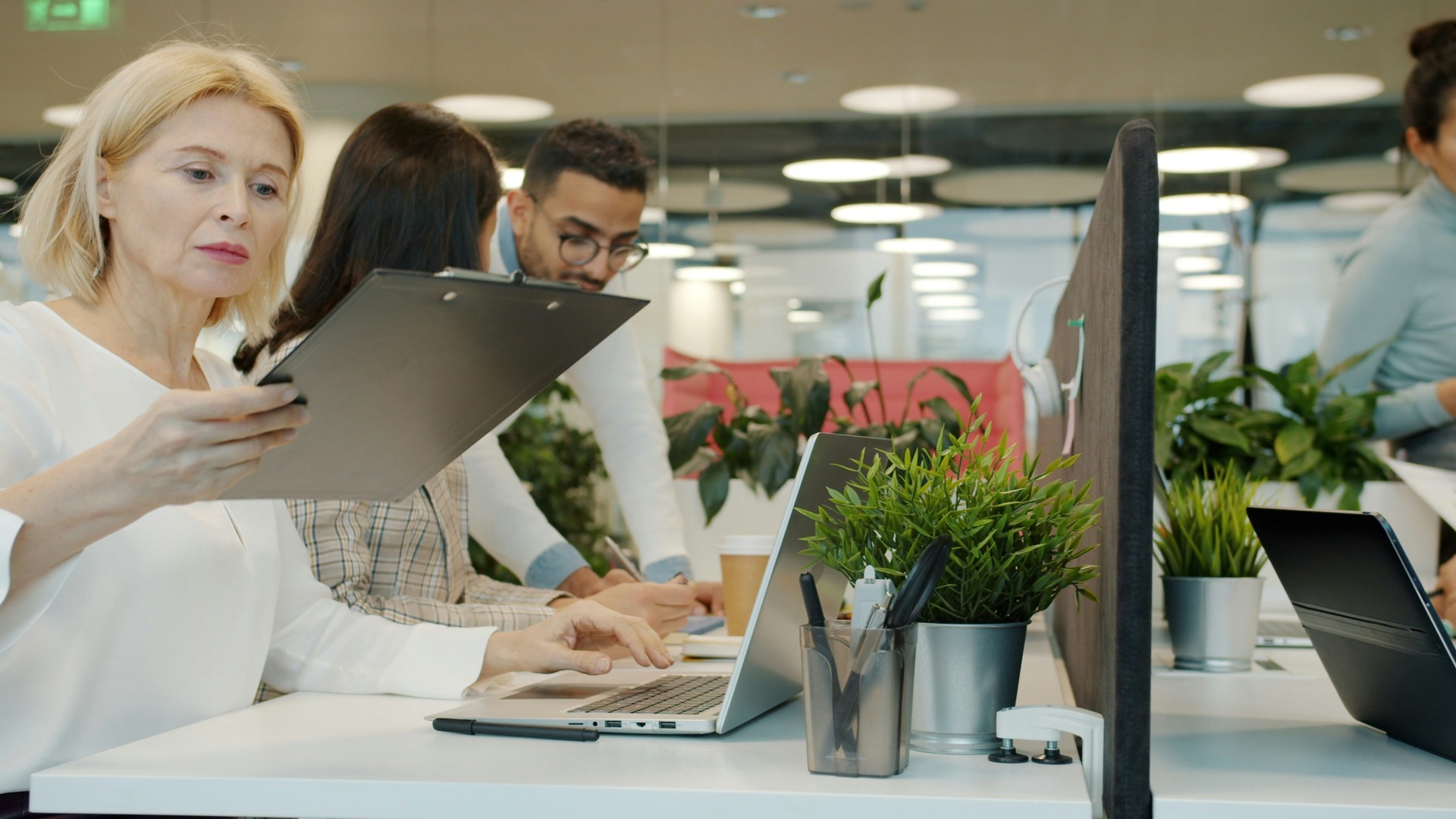 Modern business professionals collaborating with laptops in a contemporary workplace in 2025